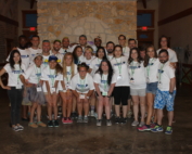 A group of people in white shirts and shorts.